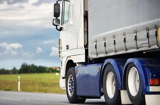 Side-view of a truck moving along the road in the day time