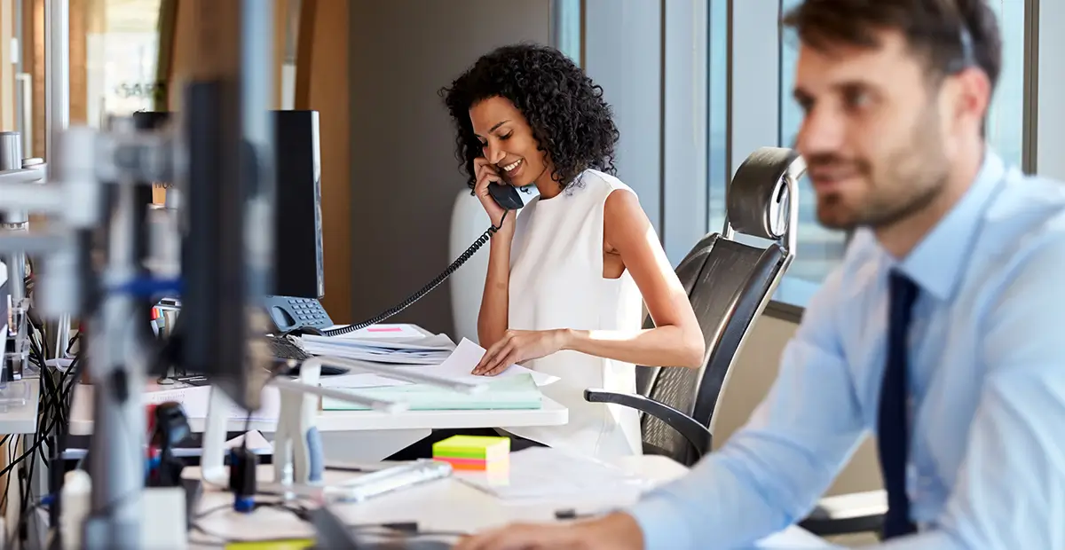 Woman smiling while holding phone up to right ear