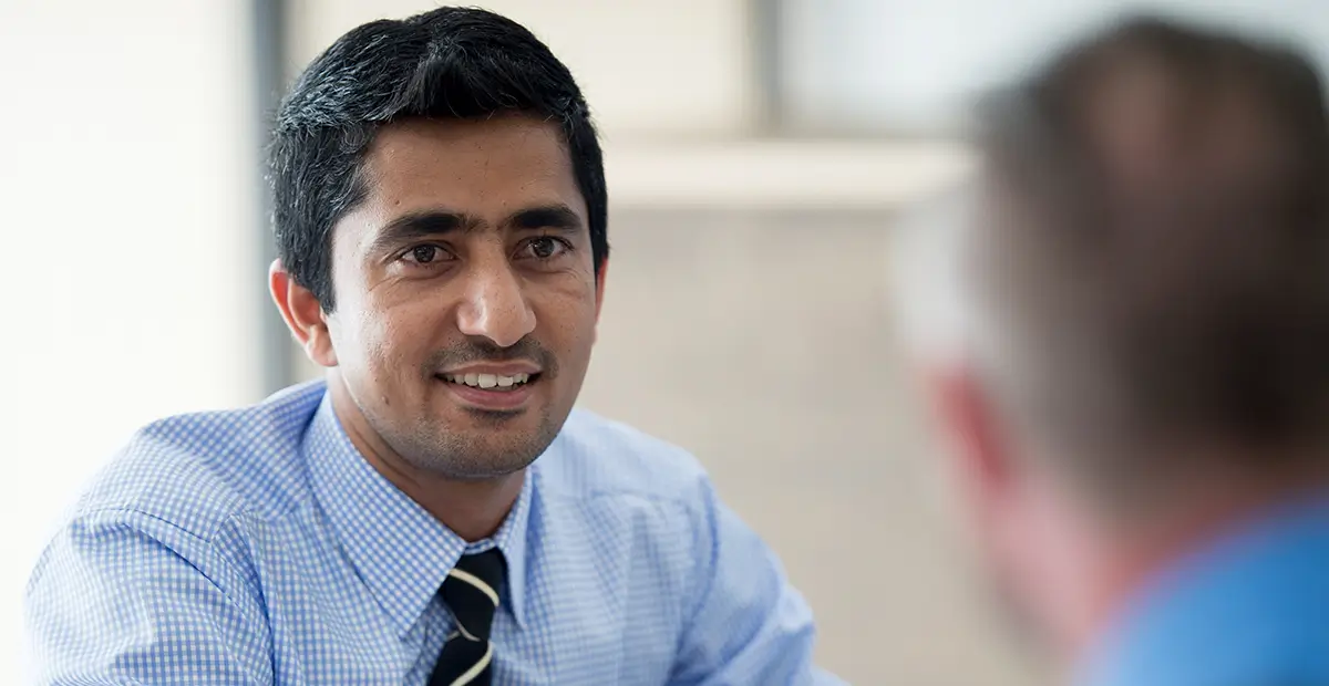 Man smiling while wearing smart shirt and tie